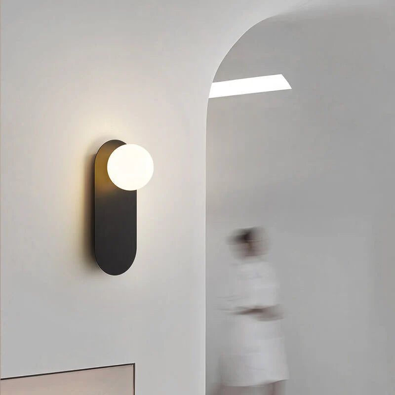 Minimalistyczna kinkietowa lampa ścienna z okrągłą szklaną podstawą