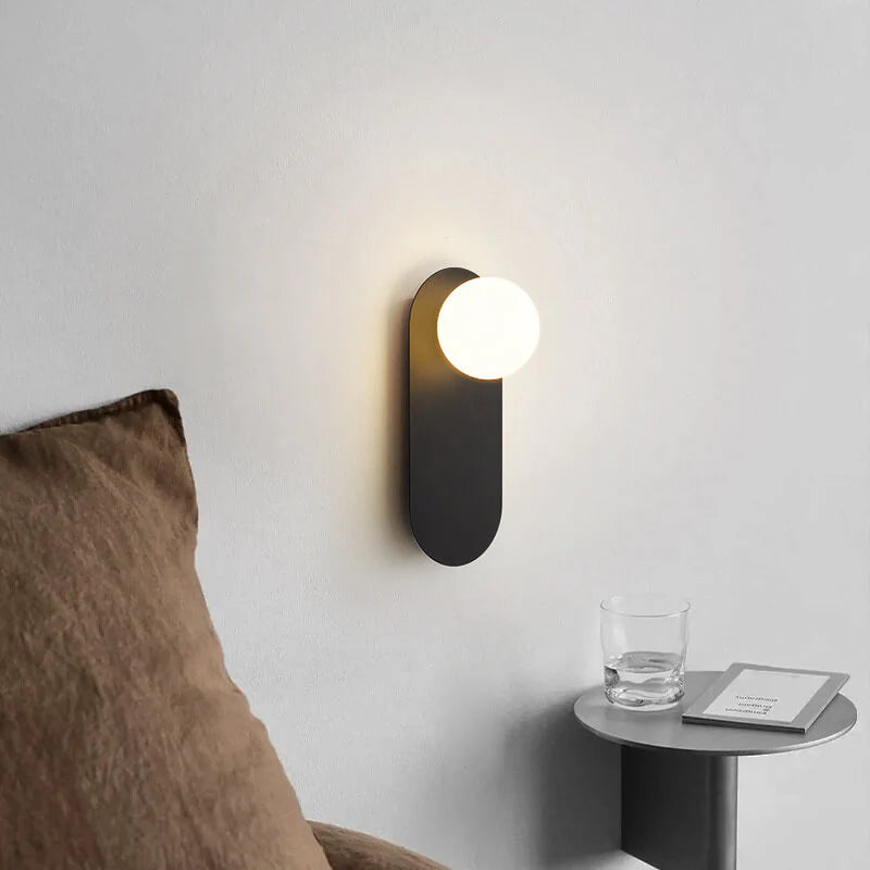 Minimalistyczna kinkietowa lampa ścienna z okrągłą szklaną podstawą