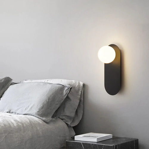 Minimalistyczna kinkietowa lampa ścienna z okrągłą szklaną podstawą