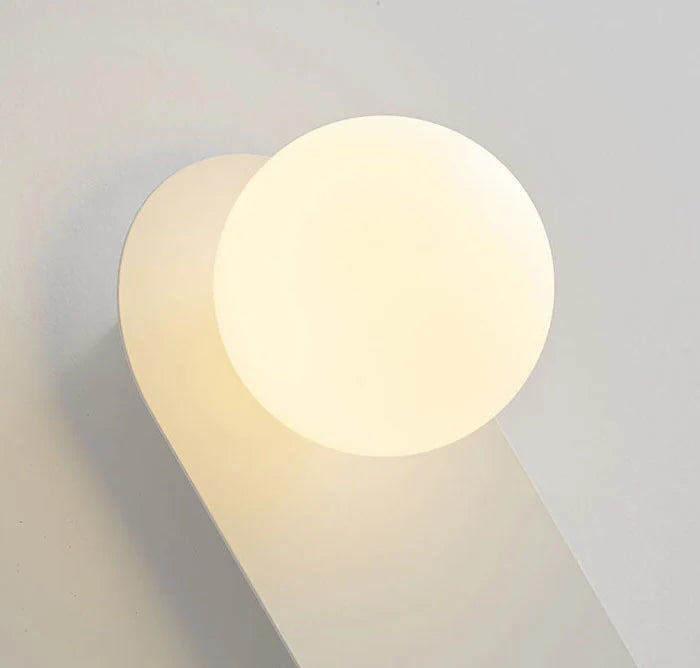 Minimalistyczna kinkietowa lampa ścienna z okrągłą szklaną podstawą