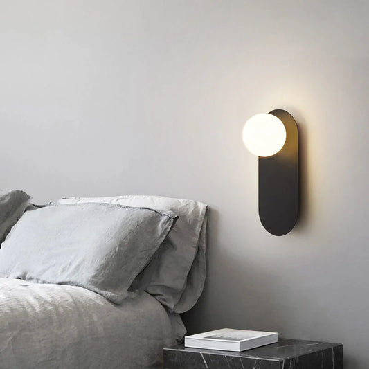 Minimalistyczna kinkietowa lampa ścienna z okrągłą szklaną podstawą